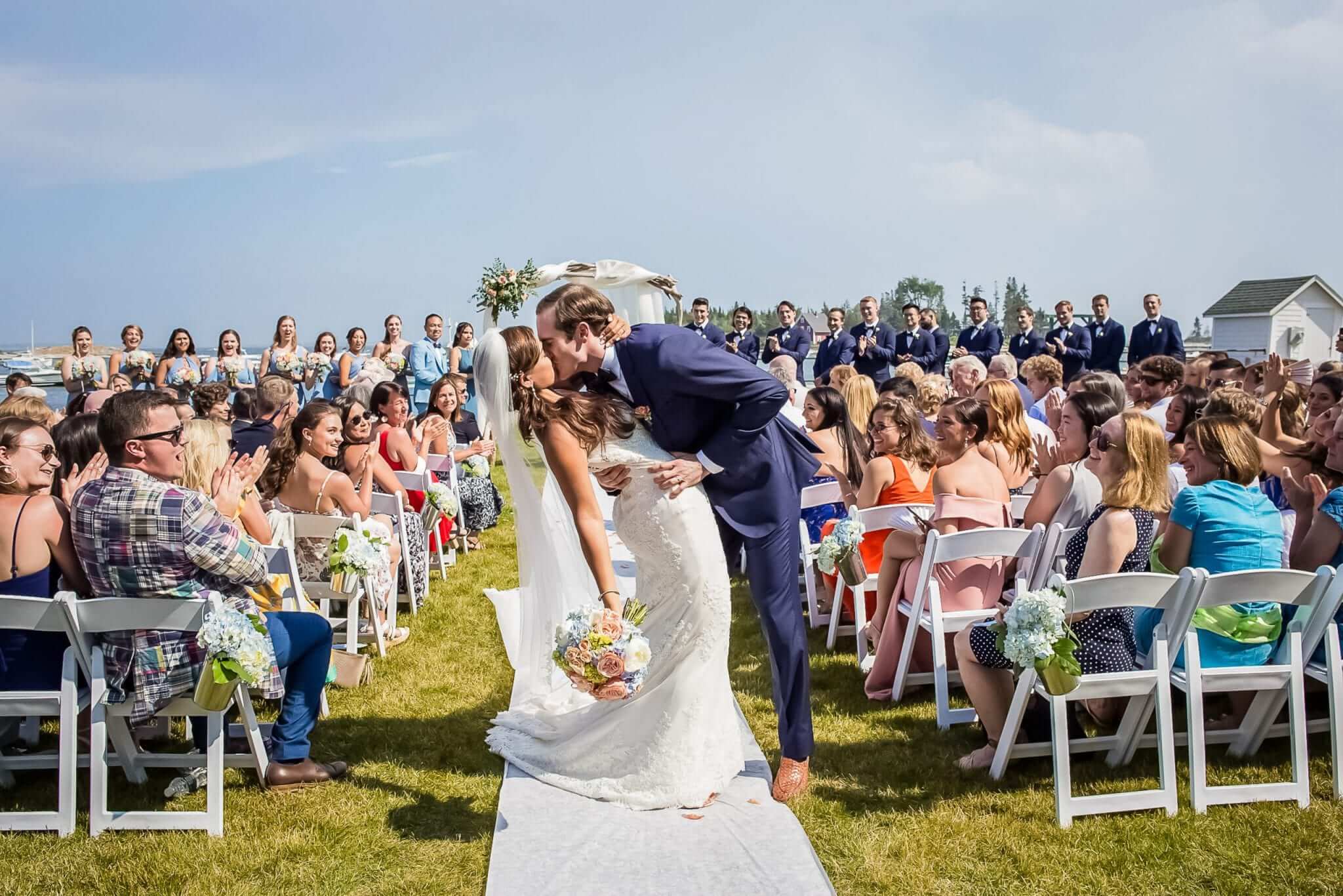 Bride and Groom kissing at outdoor wedding ceremony oceanside at Newagen Seaside Inn.