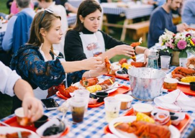 Table of guests cracking lobsters at a lobster bake reception at Newagen Seaside Inn.
