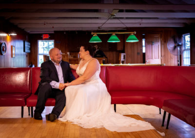 Elopement at Newagen Seaside Inn - couple sitting on a red bench in the Pine Room.