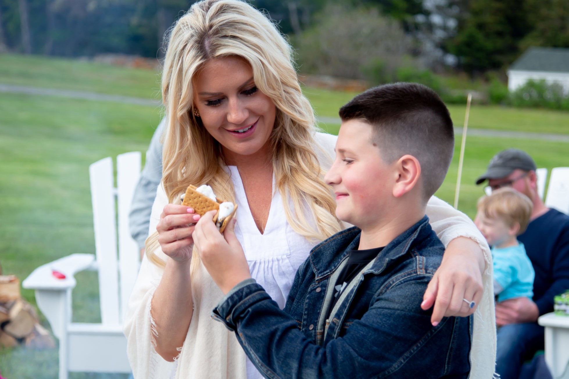 Parent and child eating smores at oceanfront hotel in Boothbay Harbor Maine